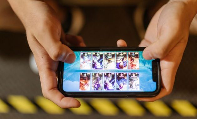 Bermain game mobile di smartphone / pexels-rdne